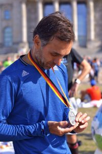 Ike Cruz admira sua medalha da Maratona de Berlim